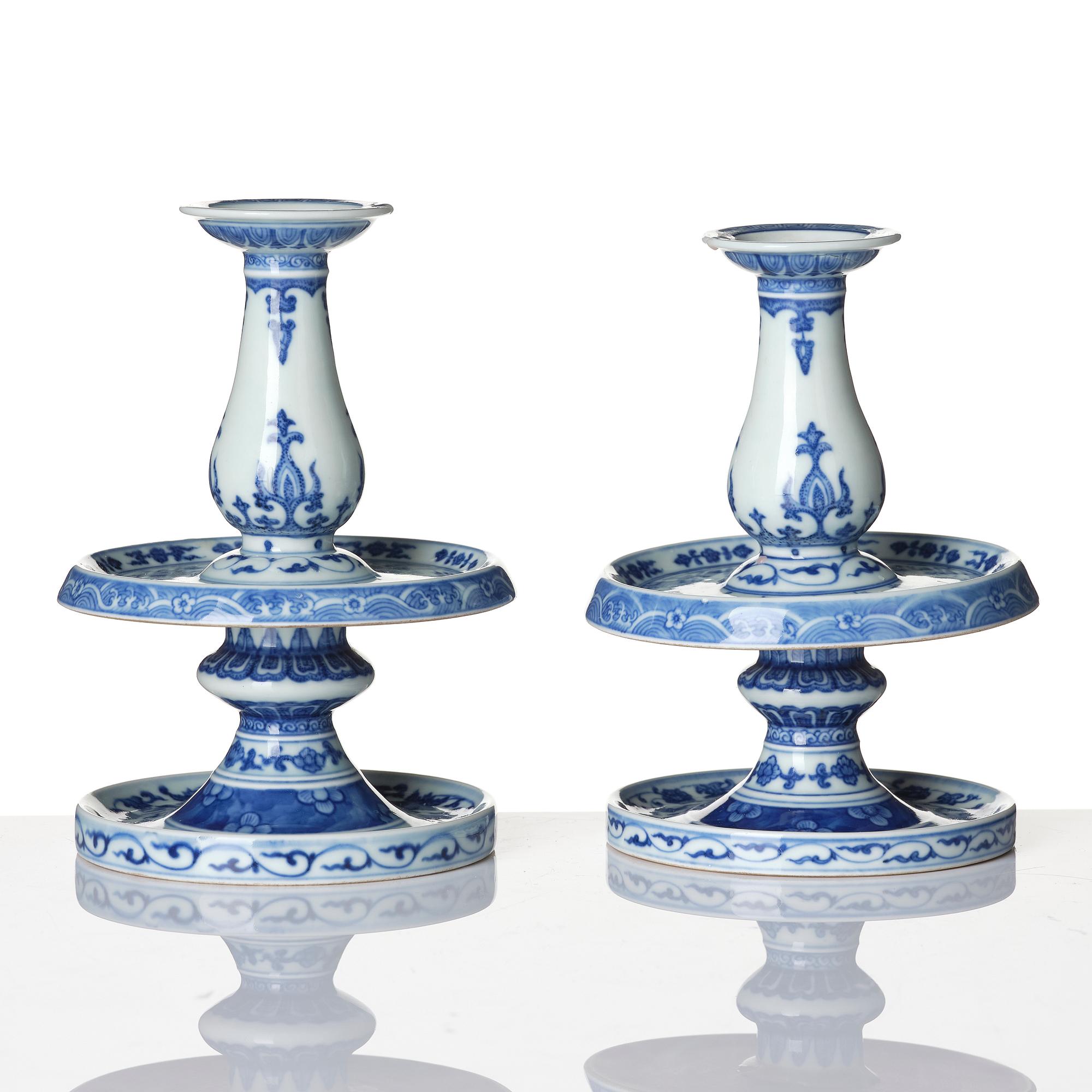 A pair of blue and white pricket candle sticks, with a poem, Qing dynasty with a Qianlong mark and of the period.