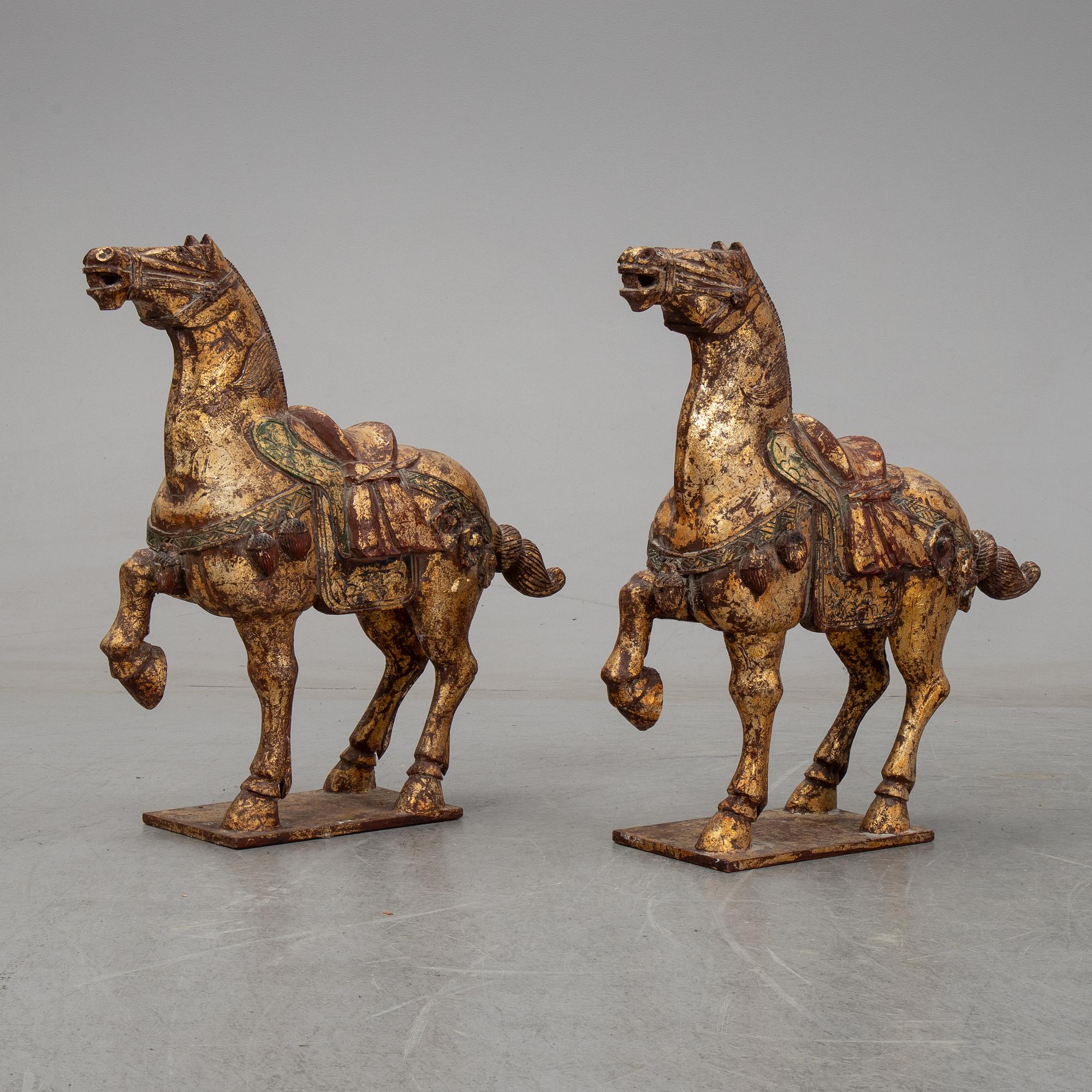 A pair of large Chinese wooden and gilt sculpture of horses, first half of the 20th century.