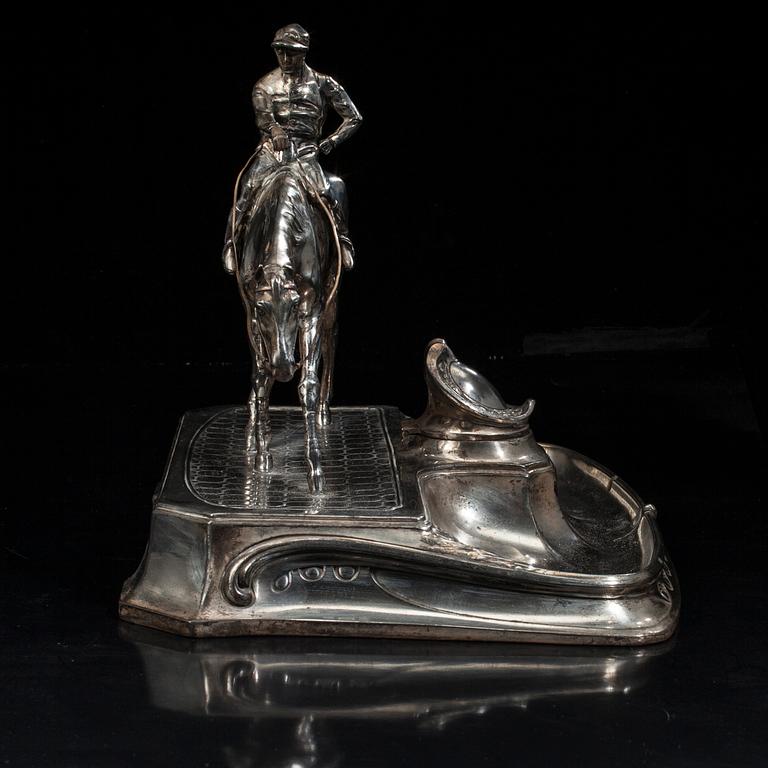SKRIVSTÄLL med jockeyn Fred Archer till häst. Vitmetall. Sannolikt England, sent 1800-tal.