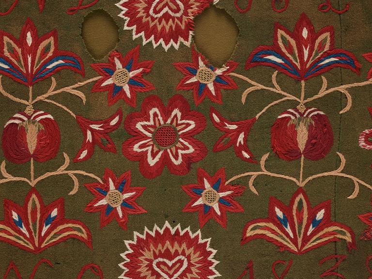 An embroidered carriage cushion, ca 51 x 113 cm (with mounting 61 x 122 cm) signed and dated END JPLG ANO 1838, Scania.