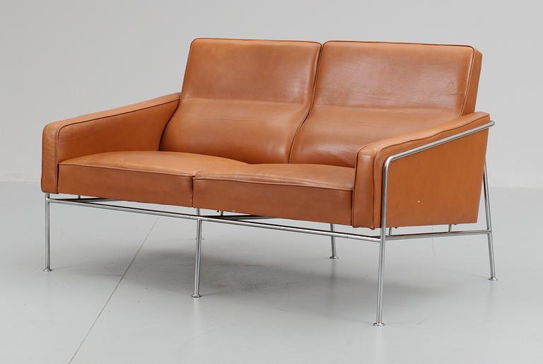An Arne Jacobsen two-seated brown leather and chromed steel sofa by Fritz Hansen, Danmark.
