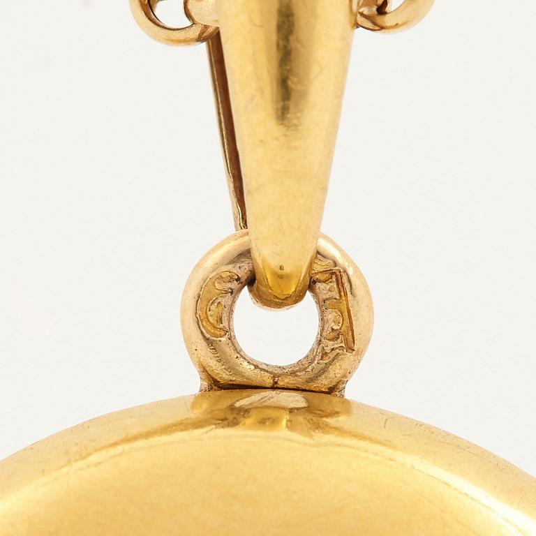An 18K gold locket set with rose-cut diamonds.