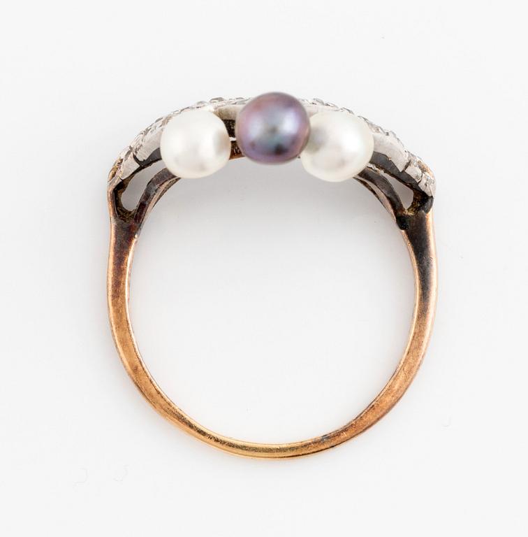 An 18K gold and platinum ring set with pearls and old-cut diamonds.