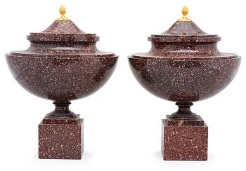 559. A pair of late Gustavian early 19th century porphyry urns with cover.