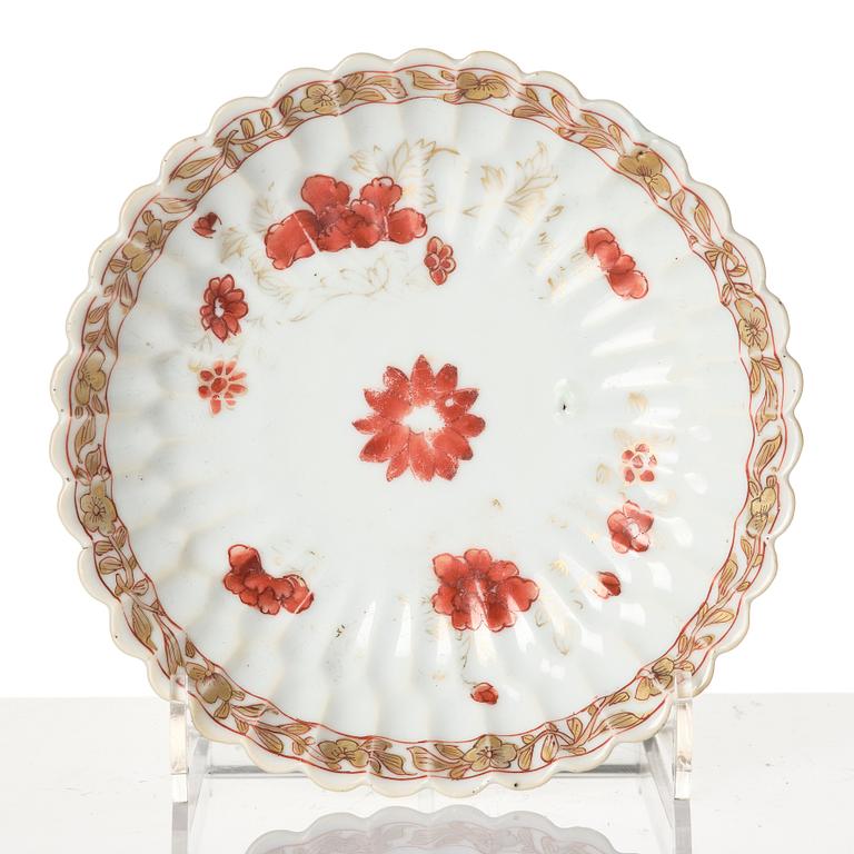 A Chinese iron red porcelain cup with saucer and a small famille verte dish, Qing dynasty, Kangxi (1662-1722).