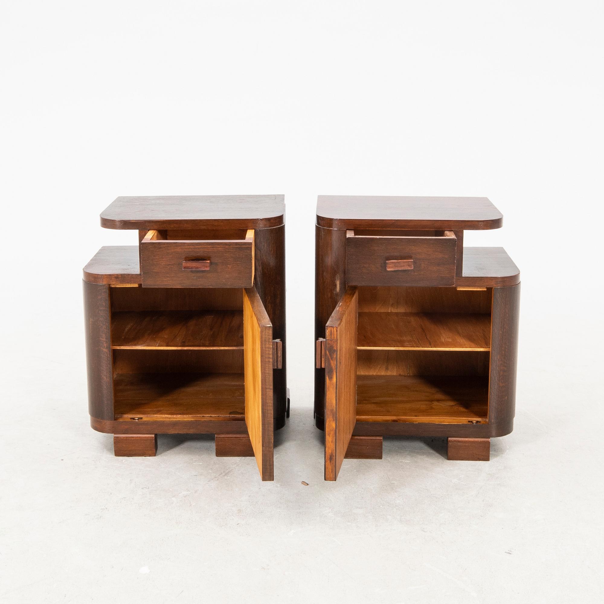 A pair of stained wood bedside tables from the first half of the 20th century.