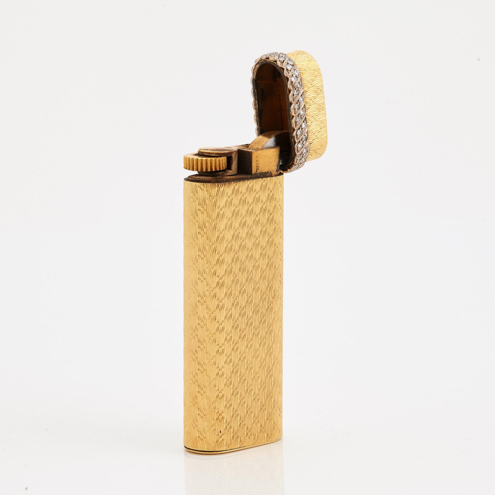 A cigarette lighter by Cartier set with single cut diamonds.