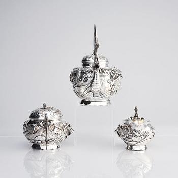 A three piece japanse silver 'dragon' tea set, Signed 三代目 大島, third generation Oshima, early 20th Century.