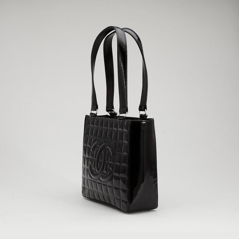 CHANEL, a quilted black patent leather top handle bag.