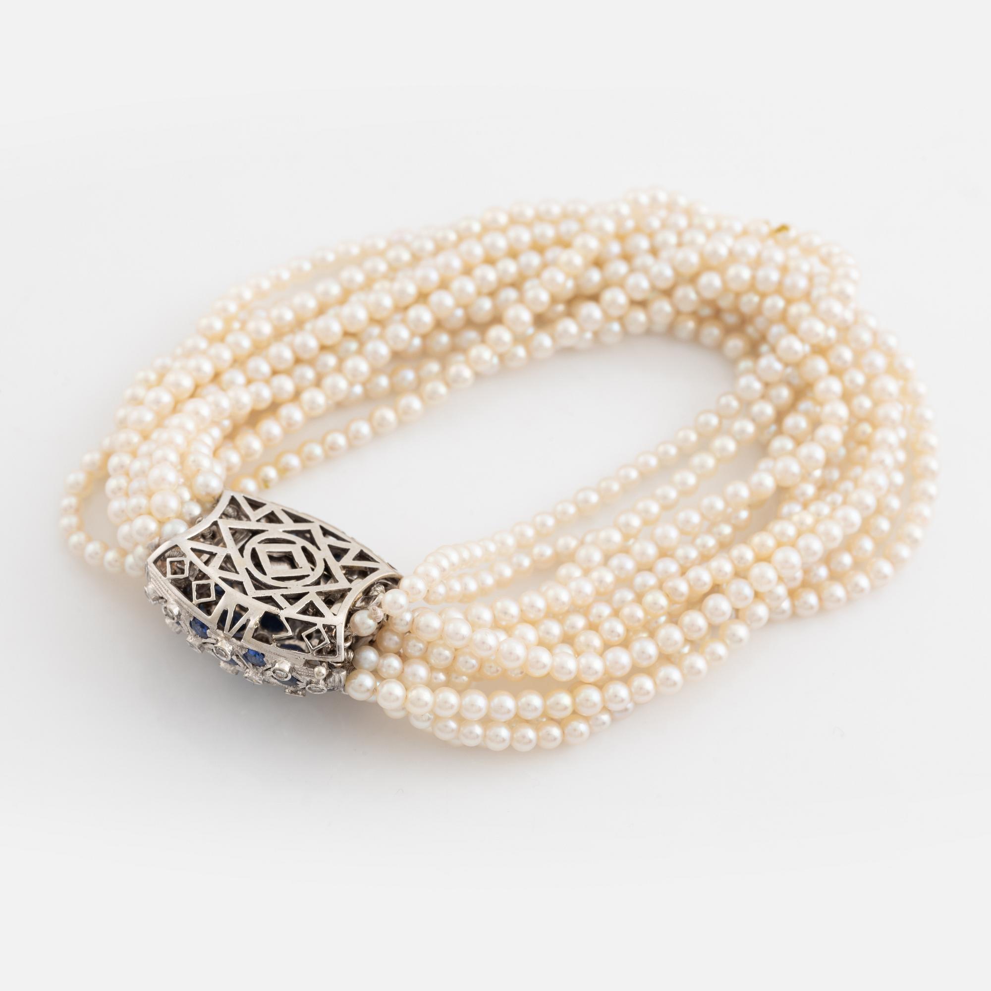 Cultured pearl bracelet, eleven strand, clasp white gold with sapphire and diamonds.