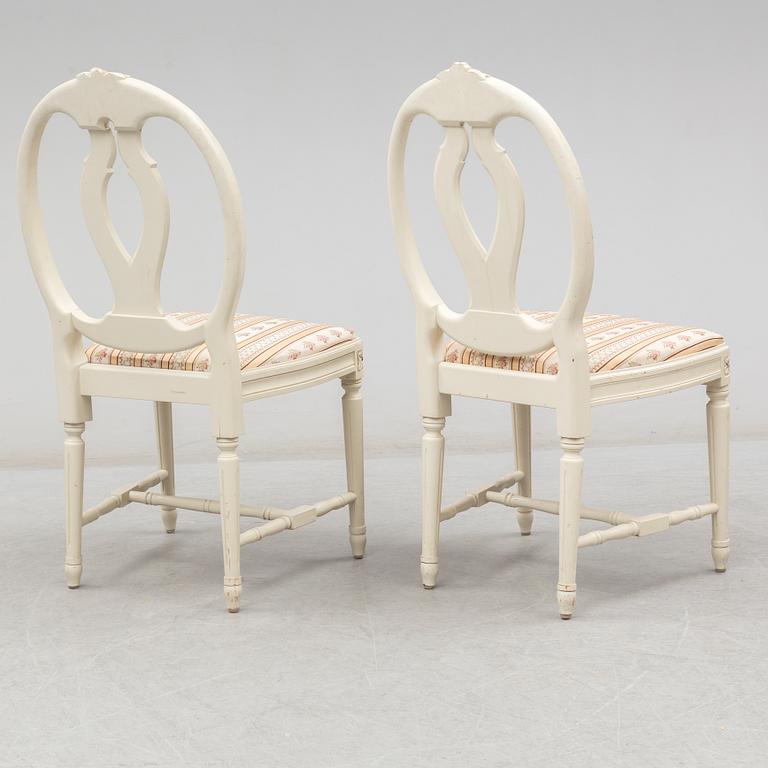 A set of eight chairs and a dining table. Gustavian style, second half of the 20th century. 2 leaves included.