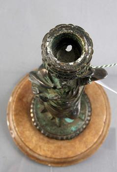 LJUSSTAKE, 1900-tal, patinerad brons med fot av marmor.