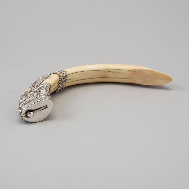 An early 20th century cigar cutter made of a wildboars tusk with silvermountings.