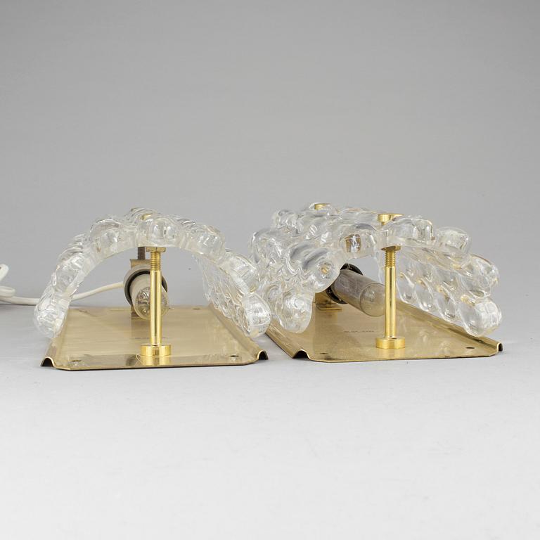 A pair of brass and glass wall lights designed by Carl Fagerlund for Orrefors.