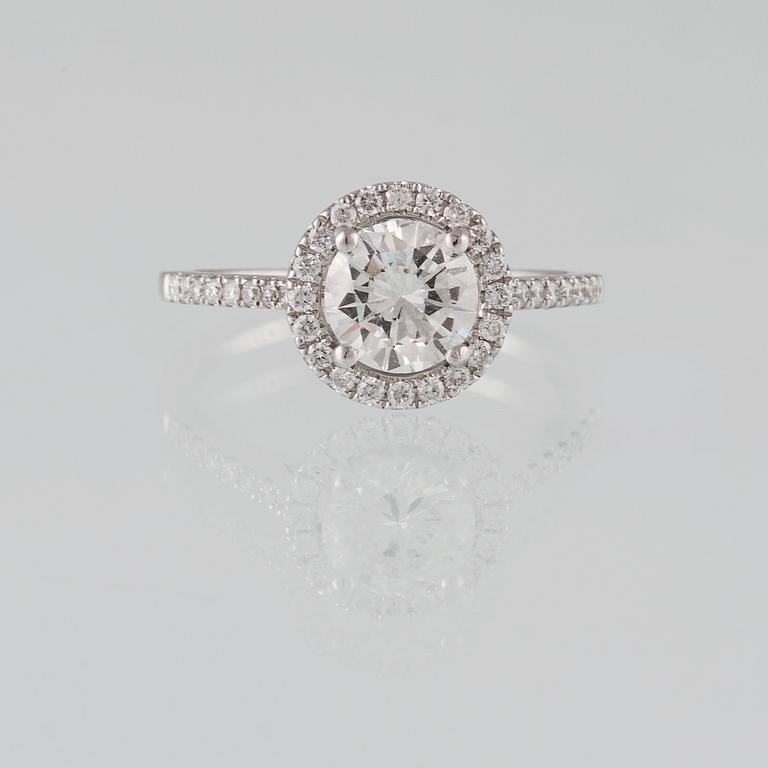 RING, 18K vitguld med briljantslipad diamant 1.07 ct samt små briljantsliapde diamanter 0.28 ct. Vikt 3.3 gram.