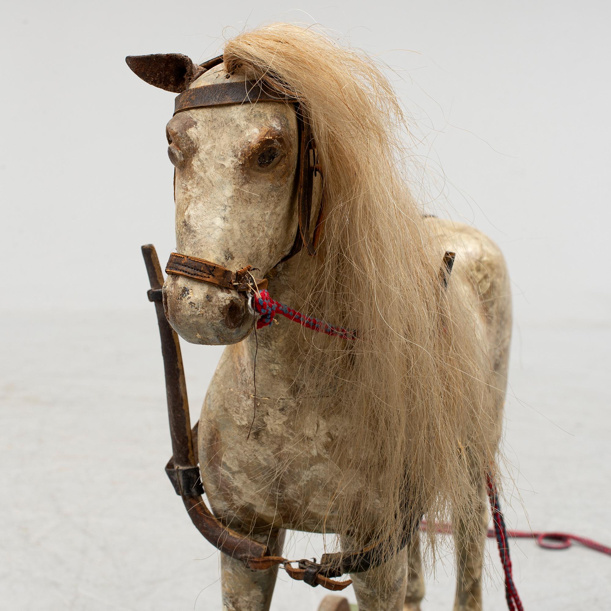 A painted early 20th century toy horse on wheels.