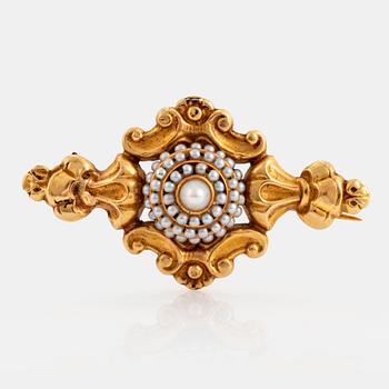 An 18K gold brooch set with pearls.