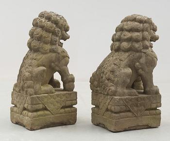 A pair of stone figures of Buddhist Lions on stands, late Qing dynasty / early 20th century..