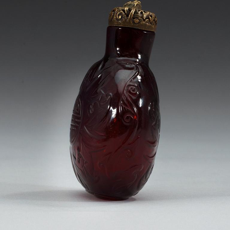 A large red sculptured peking glass snuff bottle with stopper, presumably around 1900.