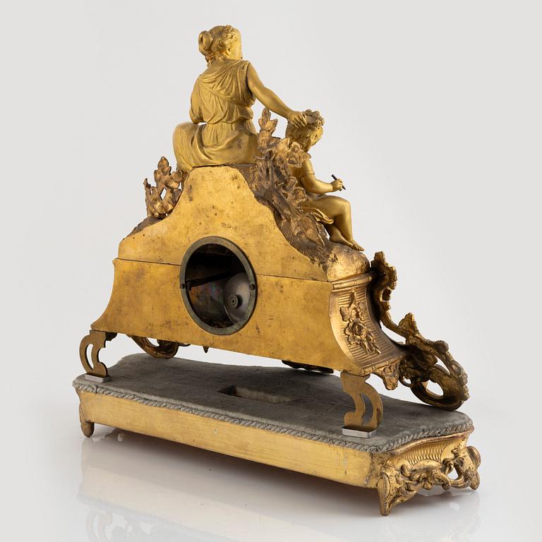 A table clock and a pair of candelabras, Louis XVI-style, France, beginning of the 20th century.
