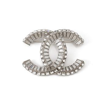 A white metal brooch by Chanel.