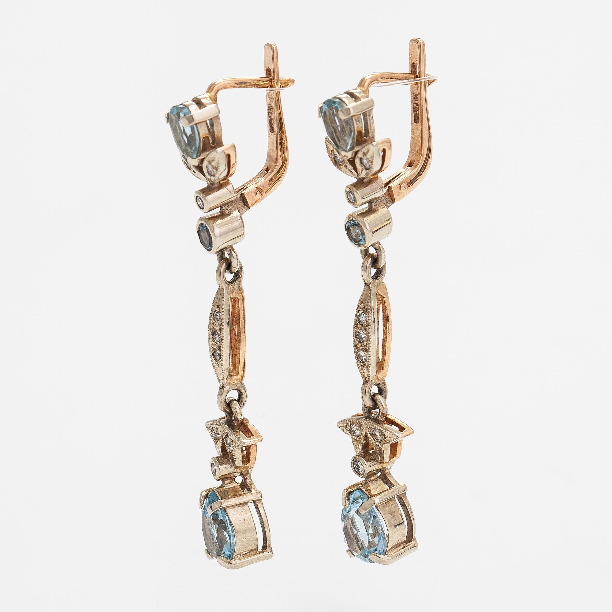 A pair of 14K gold earrings with diamonds ca. 0.18 ct in total and topazes.