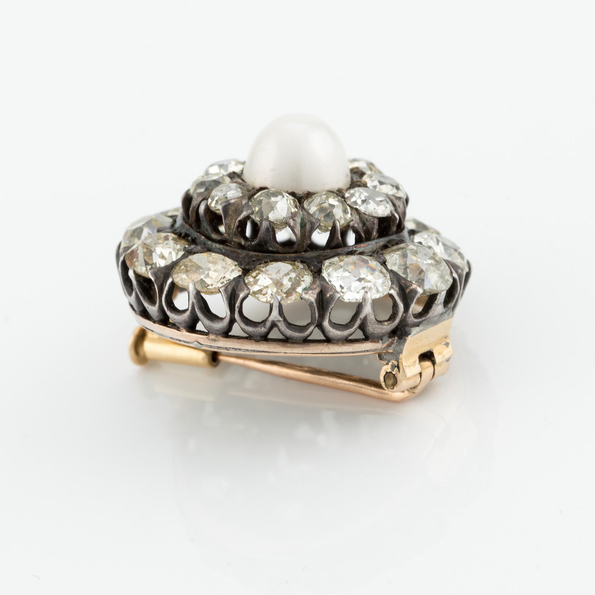 A silver and gold brooch, with cushion-cut diamonds and a pearl.