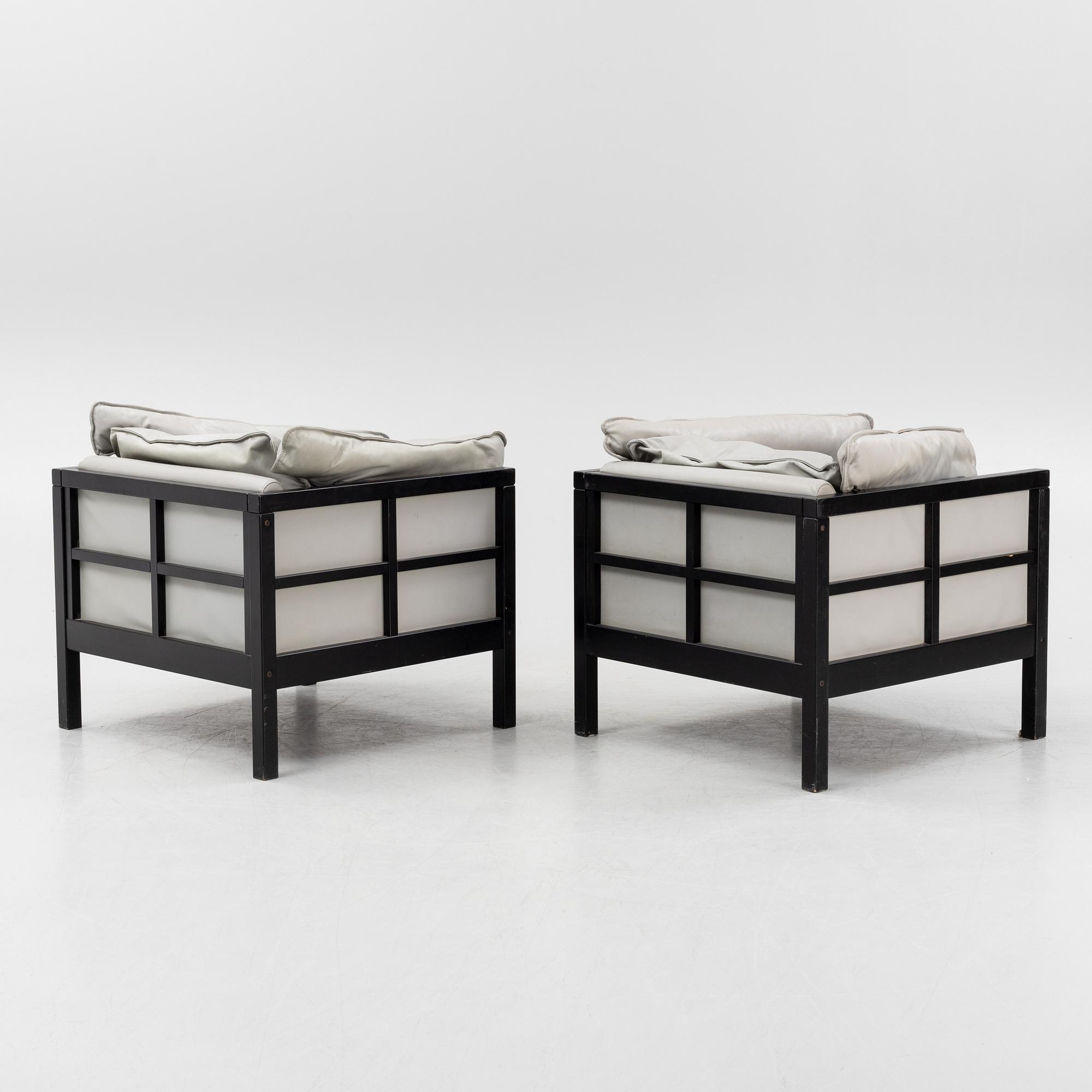 A pair of leather upholstered armchairs. End of the 20th Century.