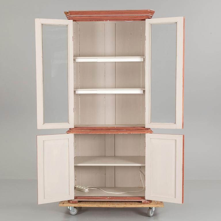 A pained late 19th century vitrine book cabinet in two sections.