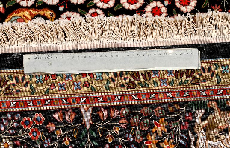 A Täbriz rug, part silk, signed, 255 x 172 cm.