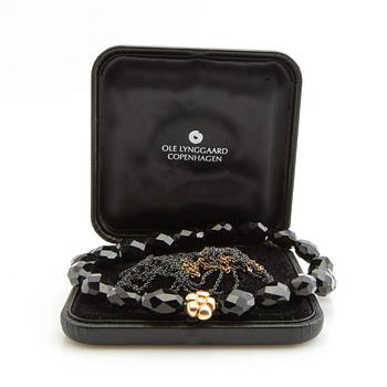 Ole Lynggaard, clasp, 18K gold with a round brilliant-cut diamond, and two necklaces.