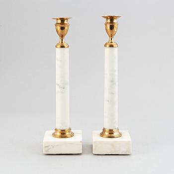 A pair of late Gustavian brass and cararra marble candle holders, around the year 1800.