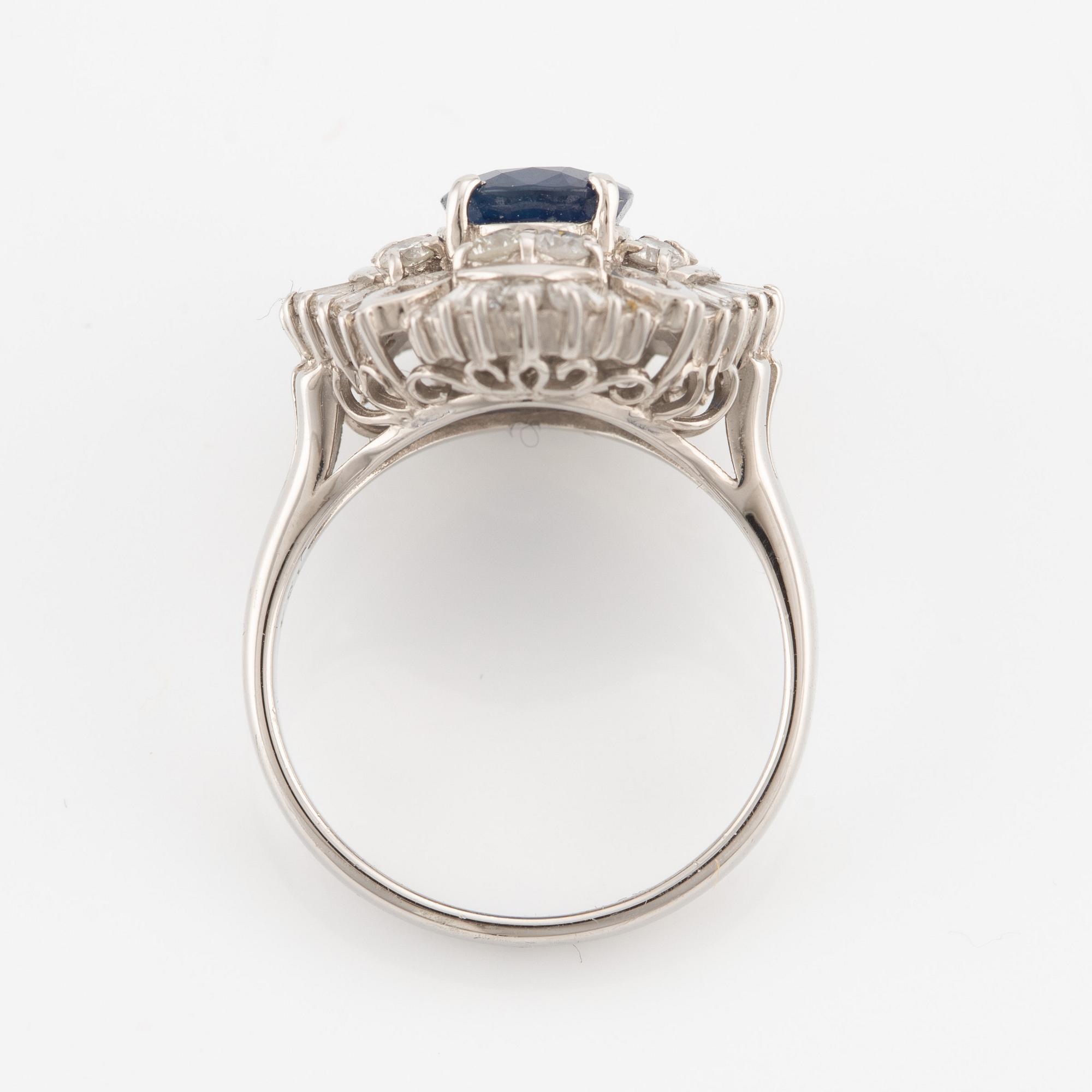 Ring in platinum set with a faceted sapphire and round brilliant- and baguette-cut diamonds.