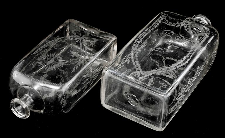 BRÄNNVINSFLASKOR, 2 st, glas, daterade 1833 respektive 1843.