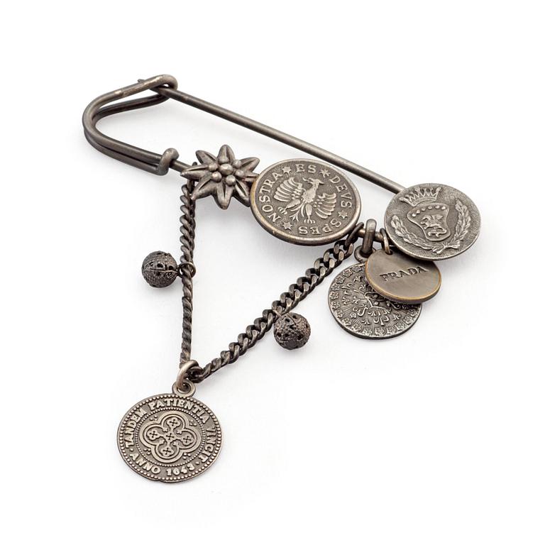 PRADA, a metal needle brooche.