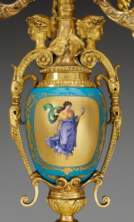 A pair of seven-light gilt bronze chandelabras with porcelain settings, 19th Century, presumably Russian.