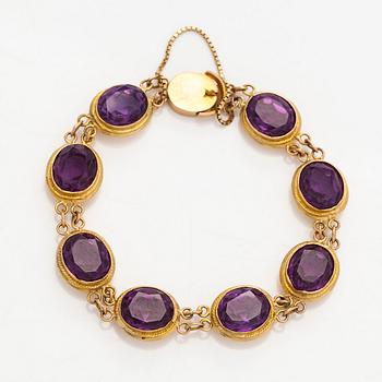 A ca. 15K gold bracelet with oval faceted synthetic sapphires.
