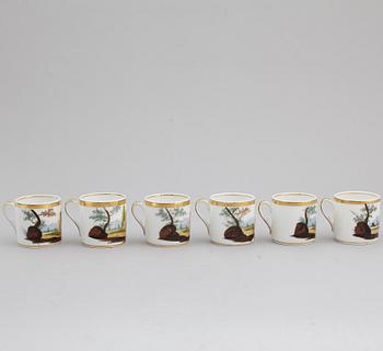 A group of seven cups, one with dish, Germany and France, 19th century.