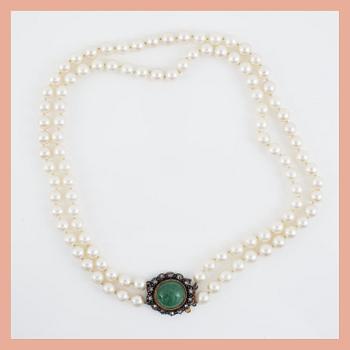 A two-strand cultured pearl necklace. Clasp with cabochon-cut emerald and rose-cut diamonds.