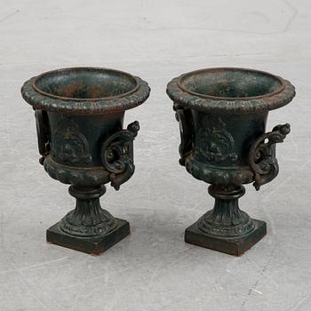 A pair of cast iron garden urns.