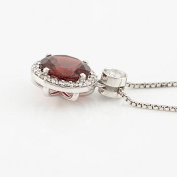 Pendant with a chain in 18K gold set with a faceted garnet and round brilliant-cut diamonds.