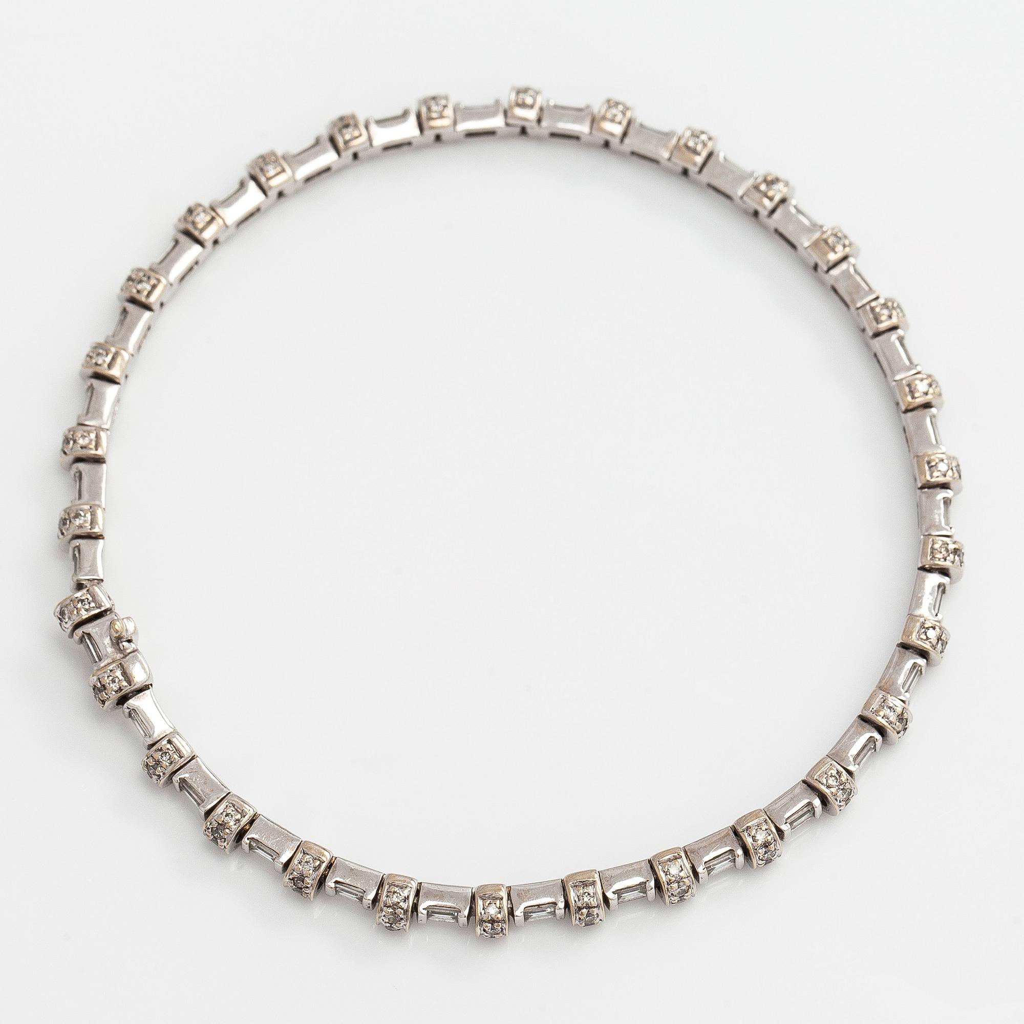 An 18K white gold bracelet set with baguette and brilliant-cut diamonds.