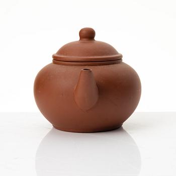 A six part red yixing Gongfu set; teapot, four cups and a tray, China, 1980s.