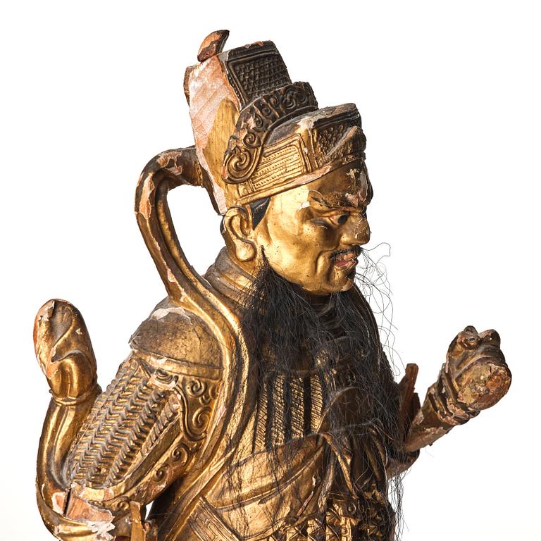 A gilt and lacquered standing figure of a guardsman, Qing dynasty.