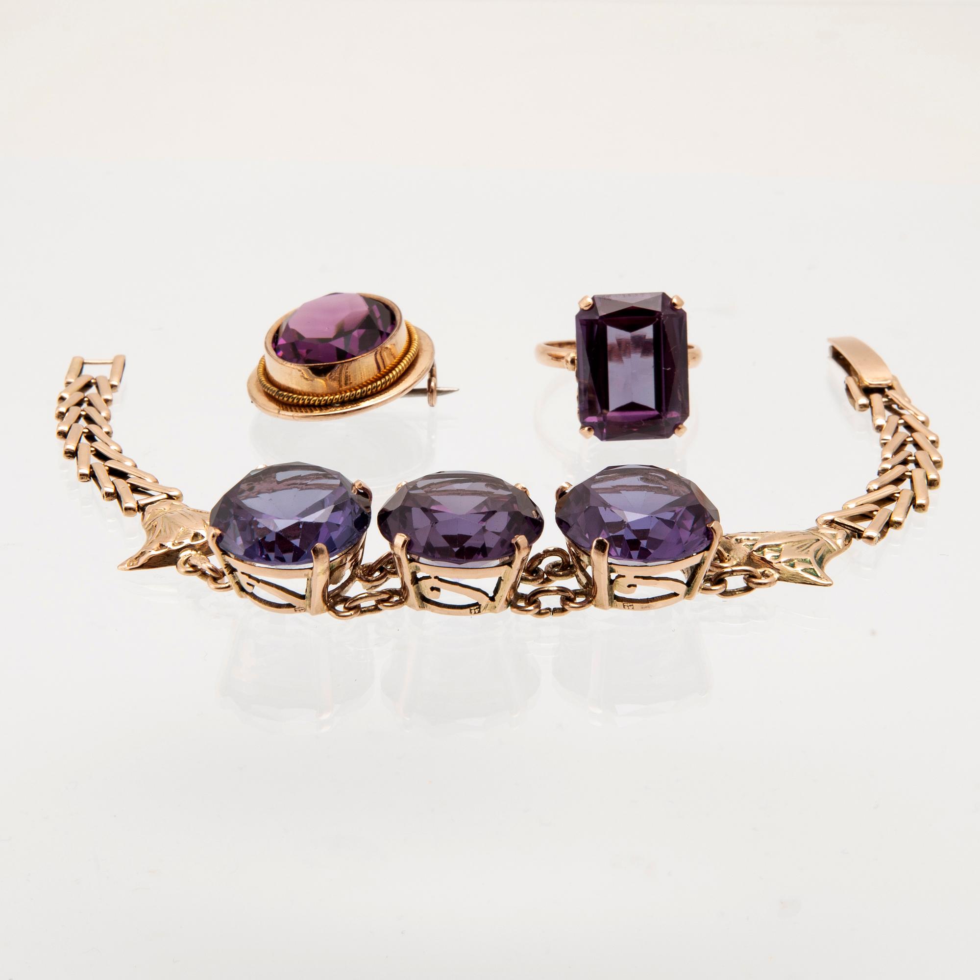Bracelet, ring, and brooch in gold with synthetic colour-changing sapphires and glass.