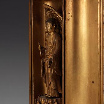 A Japanese gilt wooden figure of standing Buddha in a lacquer shrine, Meiji (1868-1912).