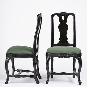 A set of eight black Swedish rococo chairs.