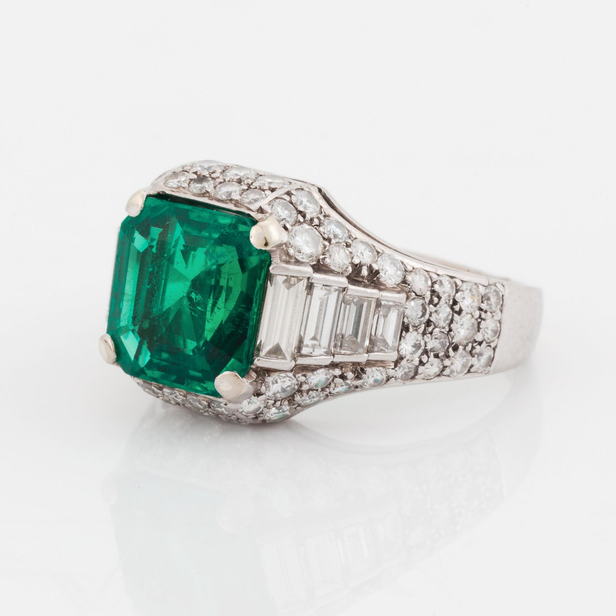 A Bulgari "Trombino" ring in platinum set with a step-cut emerald and round brilliant- and baguette-cut diamonds.