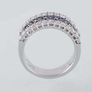 RING, 18K vitguld med 26 briljantslipade diamanter 0.88 ct samt 7 blå safirer 1.36 ct. Vikt 7,8 gram.