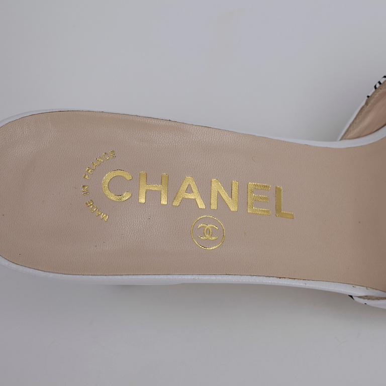 CHANEL, a pair of white leather slip in shoes.